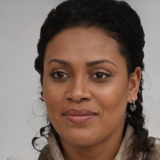 Joyful black young-adult female with long  brown hair and brown eyes