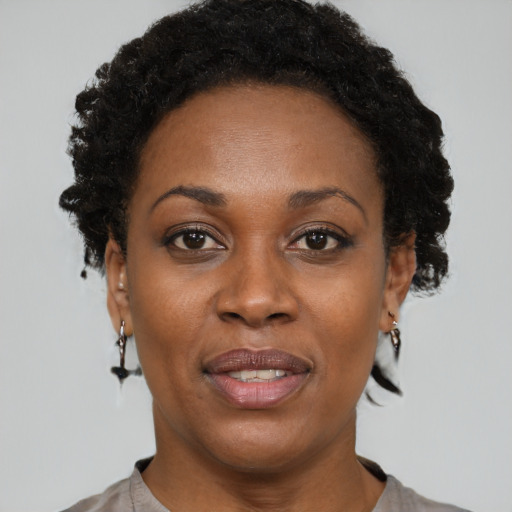 Joyful black adult female with short  brown hair and brown eyes