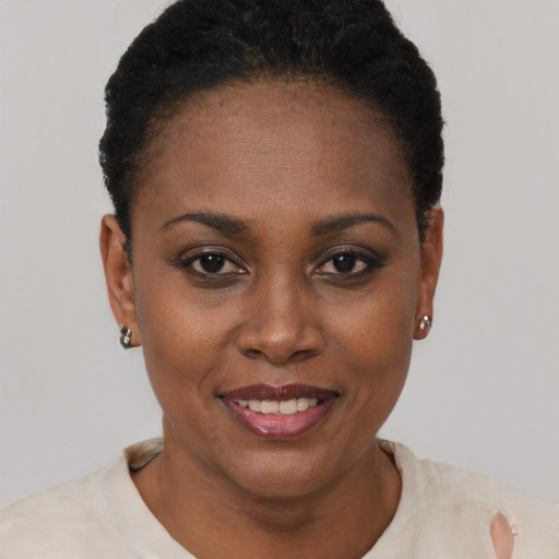 Joyful black young-adult female with short  black hair and brown eyes