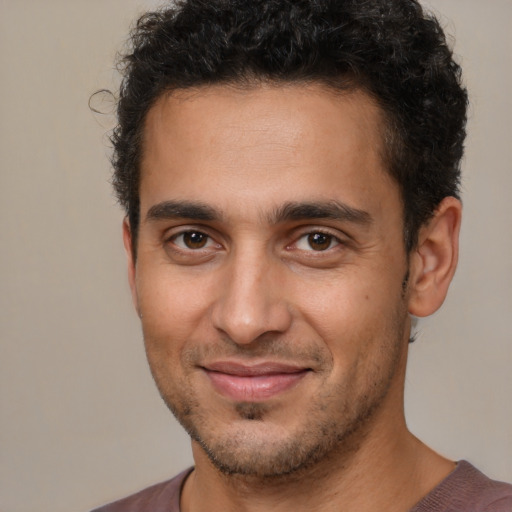 Joyful latino young-adult male with short  brown hair and brown eyes