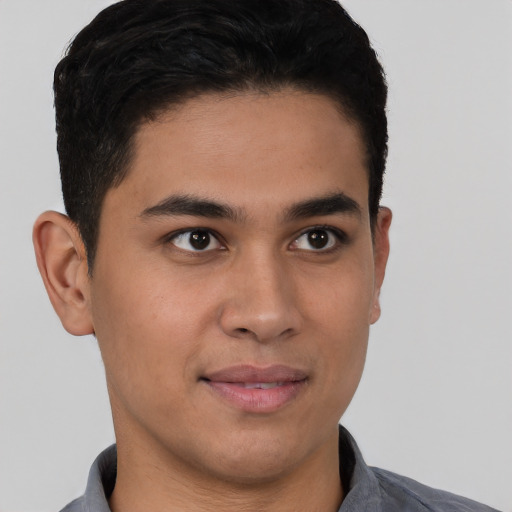 Joyful latino young-adult male with short  brown hair and brown eyes