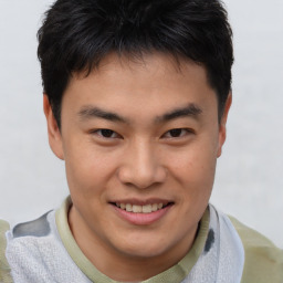 Joyful asian young-adult male with short  brown hair and brown eyes