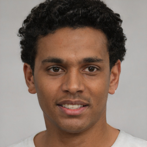 Joyful black young-adult male with short  black hair and brown eyes