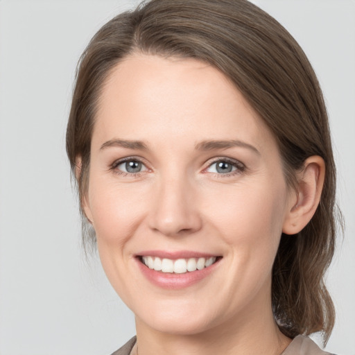 Joyful white young-adult female with medium  brown hair and grey eyes