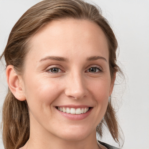 Joyful white young-adult female with long  brown hair and blue eyes