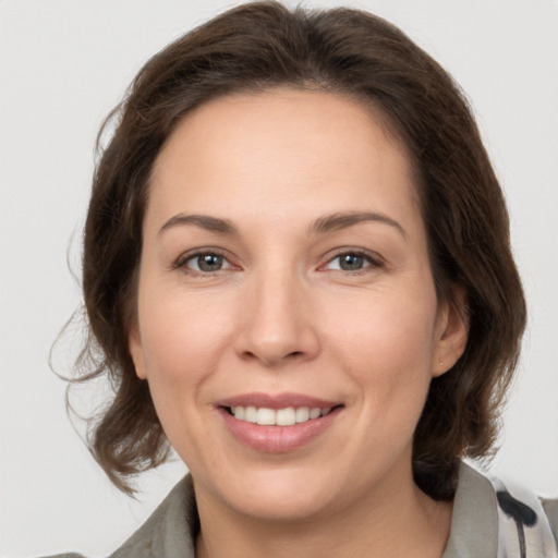 Joyful white adult female with medium  brown hair and brown eyes