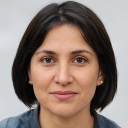 Joyful white adult female with medium  brown hair and brown eyes