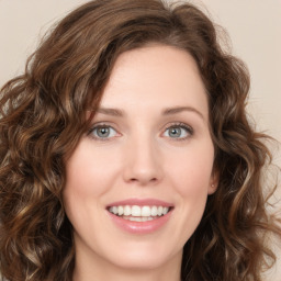 Joyful white young-adult female with long  brown hair and green eyes