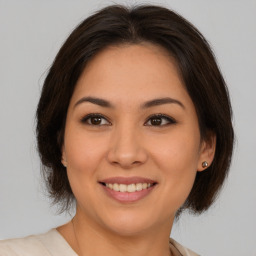 Joyful latino young-adult female with medium  brown hair and brown eyes