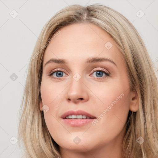 Joyful white young-adult female with long  brown hair and blue eyes