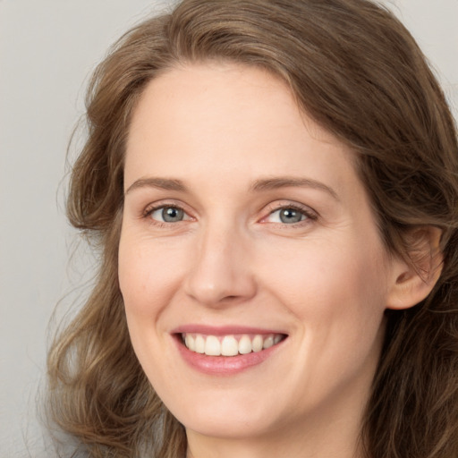 Joyful white young-adult female with long  brown hair and green eyes