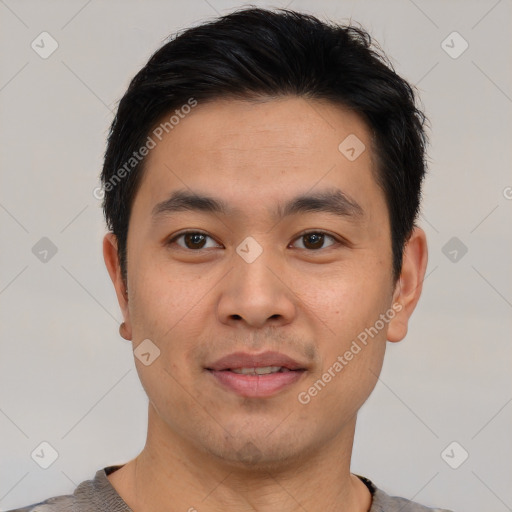 Joyful asian young-adult male with short  brown hair and brown eyes