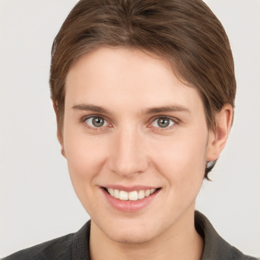 Joyful white young-adult female with short  brown hair and grey eyes