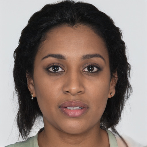 Joyful black young-adult female with long  brown hair and brown eyes