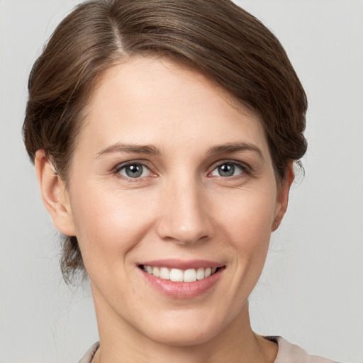 Joyful white young-adult female with short  brown hair and grey eyes