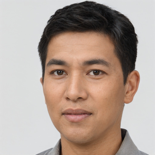 Joyful asian young-adult male with short  black hair and brown eyes
