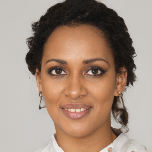 Joyful black young-adult female with short  brown hair and brown eyes