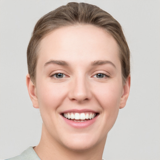 Joyful white young-adult female with short  brown hair and grey eyes