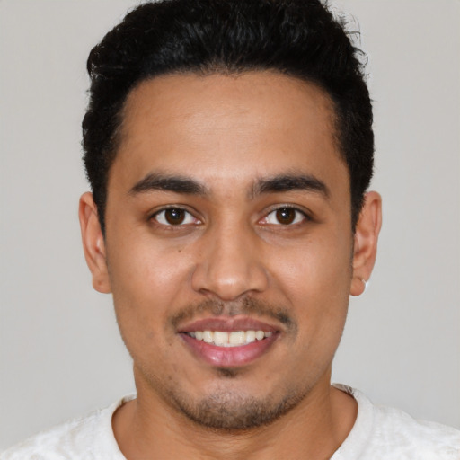 Joyful latino young-adult male with short  black hair and brown eyes