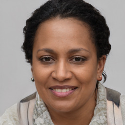 Joyful black adult female with medium  brown hair and brown eyes