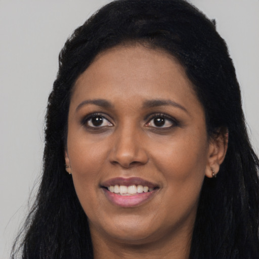 Joyful black young-adult female with long  black hair and brown eyes