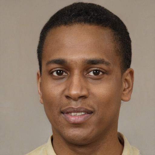 Joyful black young-adult male with short  brown hair and brown eyes