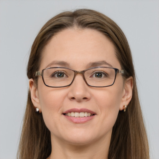 Joyful white adult female with long  brown hair and grey eyes