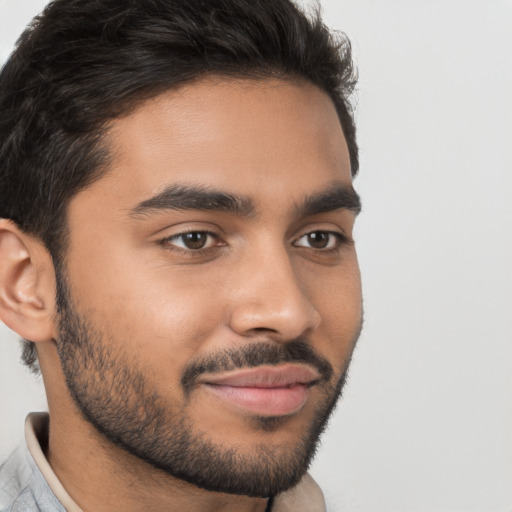 Joyful latino young-adult male with short  brown hair and brown eyes