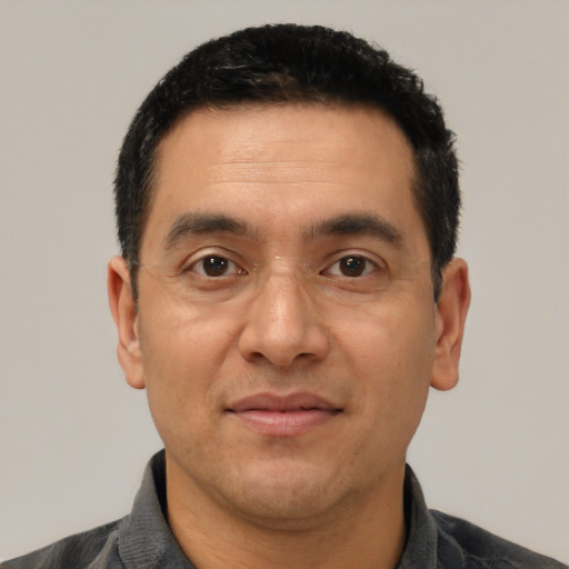 Joyful latino adult male with short  black hair and brown eyes