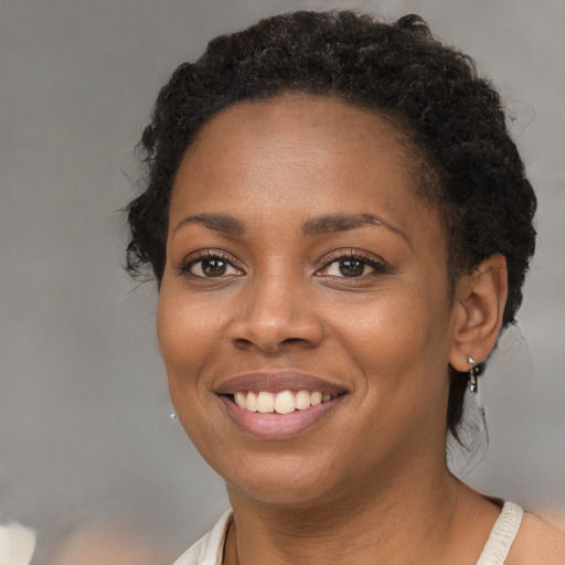 Joyful black young-adult female with medium  brown hair and brown eyes