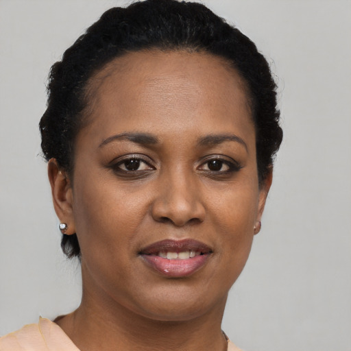 Joyful black young-adult female with short  brown hair and brown eyes