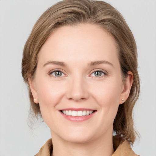 Joyful white young-adult female with medium  brown hair and grey eyes