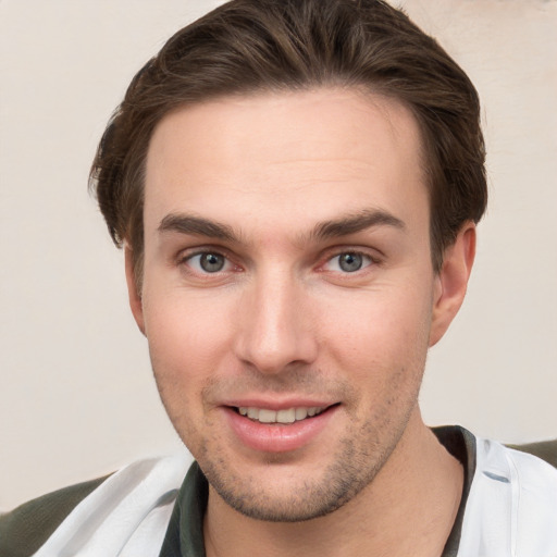 Joyful white young-adult male with short  brown hair and grey eyes