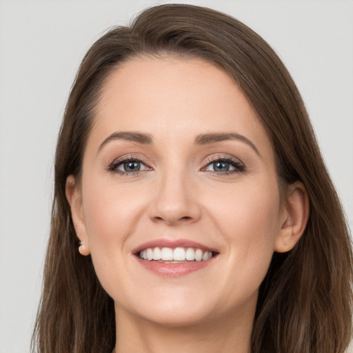 Joyful white young-adult female with long  brown hair and grey eyes