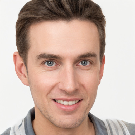 Joyful white young-adult male with short  brown hair and grey eyes