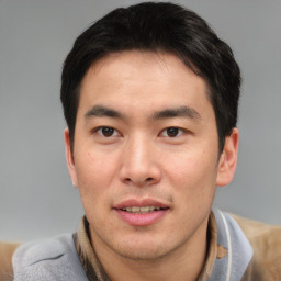 Joyful asian young-adult male with short  brown hair and brown eyes