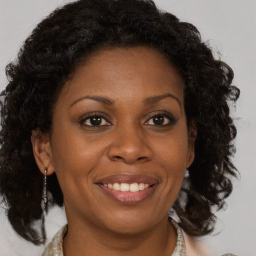 Joyful black adult female with medium  brown hair and brown eyes