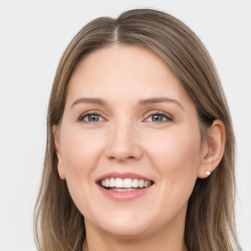 Joyful white young-adult female with long  brown hair and grey eyes