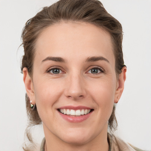 Joyful white young-adult female with medium  brown hair and grey eyes