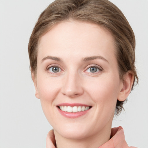 Joyful white young-adult female with medium  brown hair and blue eyes