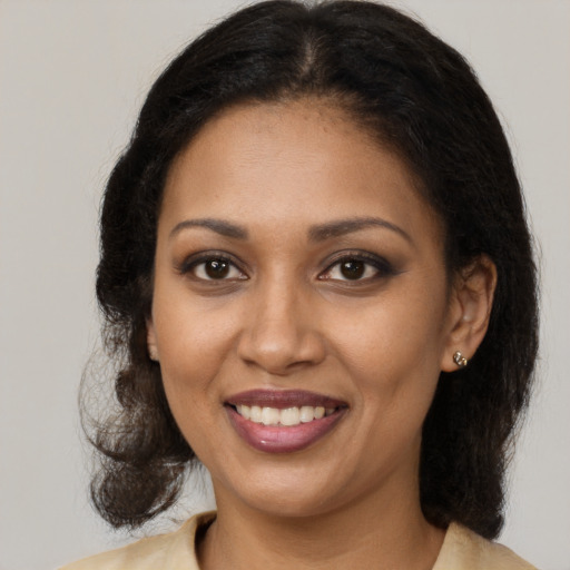 Joyful black young-adult female with long  brown hair and brown eyes