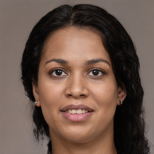 Joyful black young-adult female with long  brown hair and brown eyes