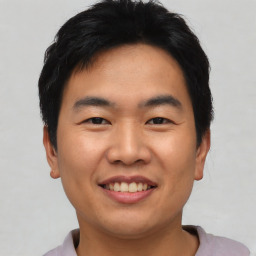 Joyful asian young-adult male with short  black hair and brown eyes