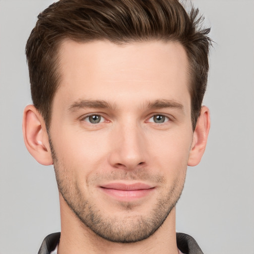 Joyful white young-adult male with short  brown hair and grey eyes