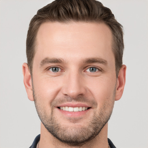 Joyful white young-adult male with short  brown hair and grey eyes