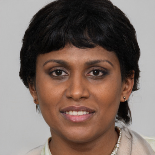 Joyful latino young-adult female with short  black hair and brown eyes