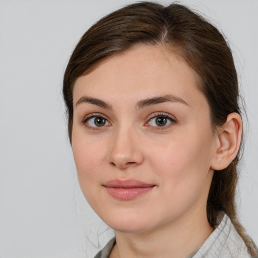 Joyful white young-adult female with medium  brown hair and grey eyes