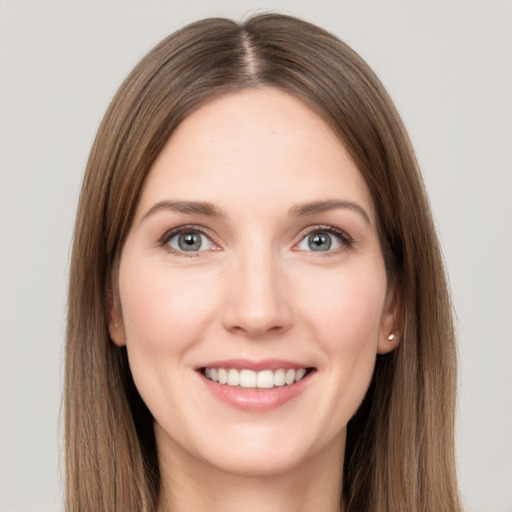 Joyful white young-adult female with long  brown hair and grey eyes