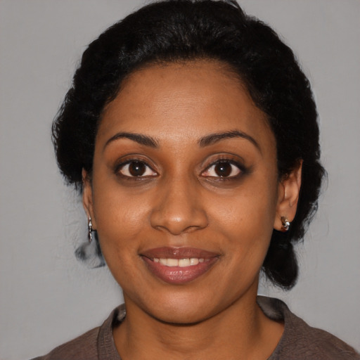 Joyful black young-adult female with medium  black hair and brown eyes