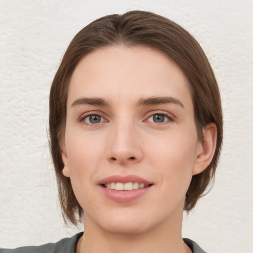 Joyful white young-adult female with medium  brown hair and grey eyes